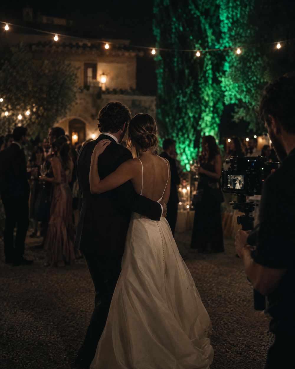 A couple dancing in a garden at night